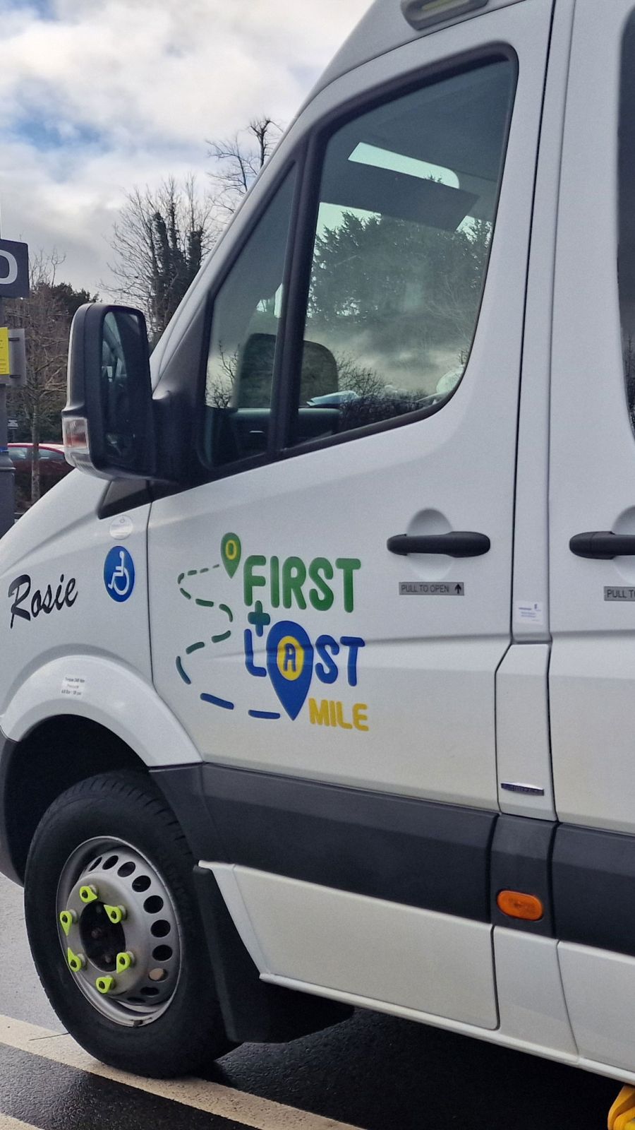 A white bus displaying the words "First & last Mile" prominently on its side.