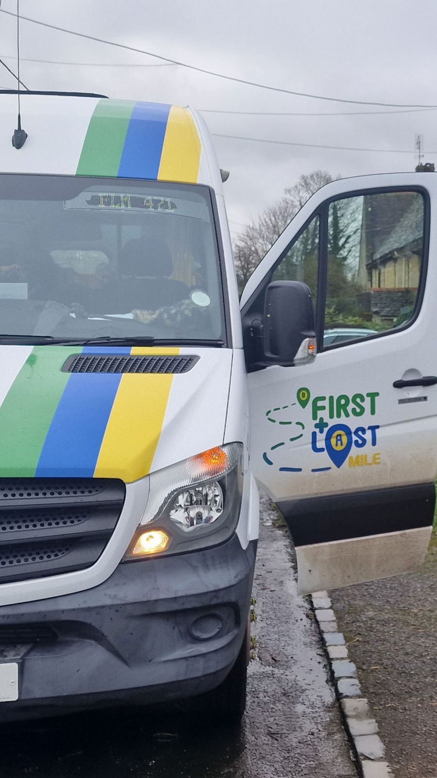 A white bus displaying the words "First & last Mile" prominently on its side. 