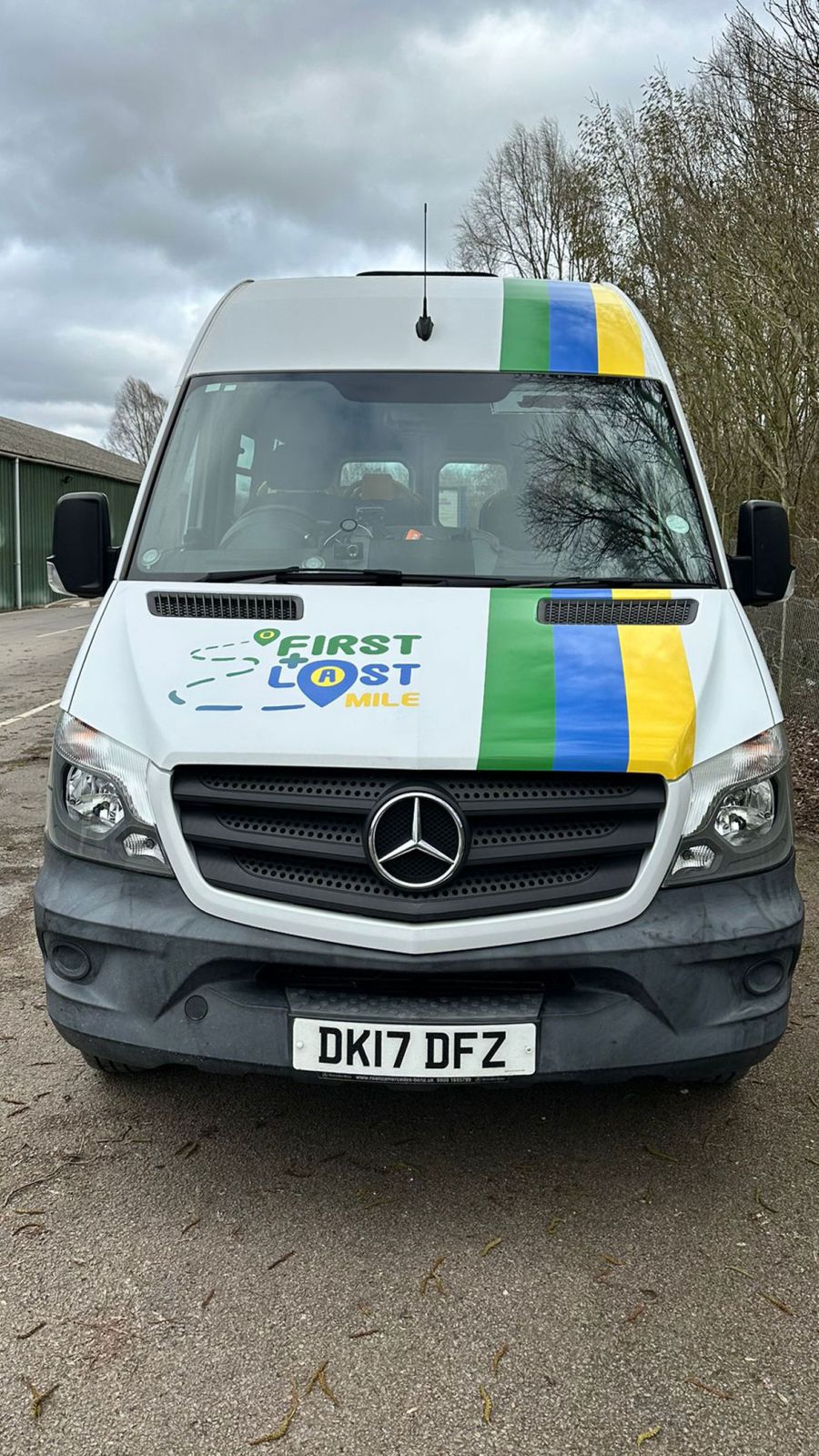 A white bus displaying the words "First & last Mile" prominently on its front.